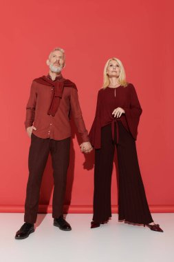 Şık bir son sınıf çifti canlı bir ortamda güven içinde poz verir..