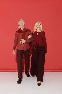 Bir çift el ele yürür, zarif kıyafetlerini ve neşeli bağlantılarını sergilerler..