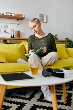 Genç bir kadın günlüklerini canlı bir kanepede sıcak, sıcak bir atmosfere daldırıyor..