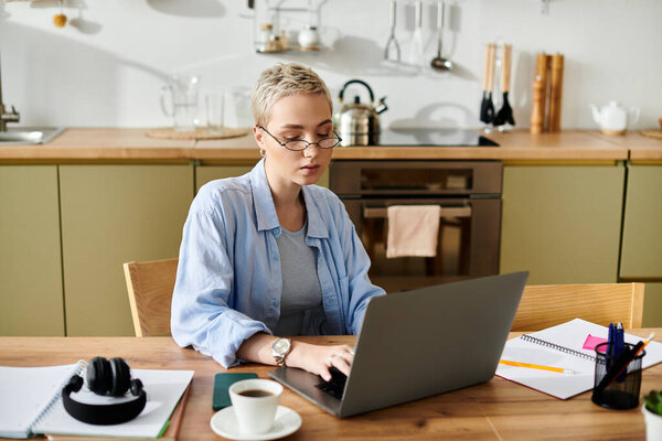 Сосредоточенные молодые женщины на своем ноутбуке в уютной кухне, наслаждаясь чашкой кофе.