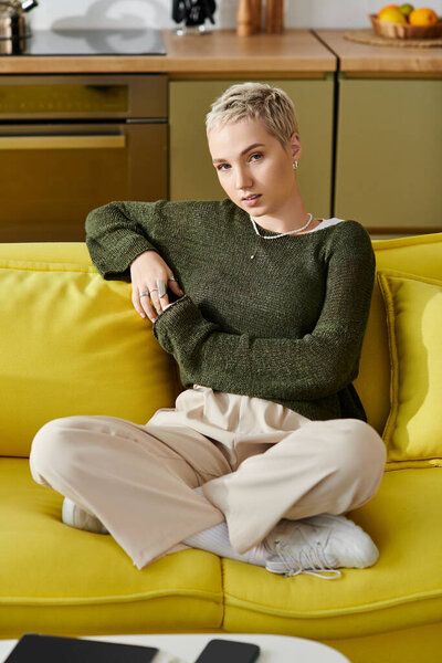 A young woman with short hair sits on a bright yellow couch, radiating tranquility.