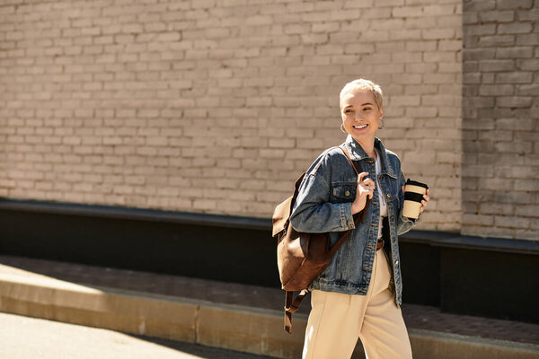 Веселая молодая женщина прогуливается по городской местности, обнимая яркую атмосферу вокруг себя.