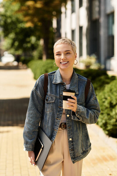 Brightly lit outdoor stroll features a cheerful young woman with short hair holding a coffee cup.