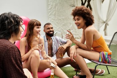 Genç şık arkadaşlar havuz partisi ortamında içki, kahkaha ve eğlence eşliğinde kaynaşırlar..