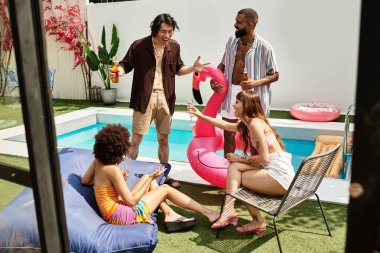 Genç arkadaşlar havuz kenarında dinlenirken kahkaha ve içkinin keyfini çıkarıyorlar..