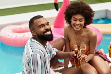 Genç arkadaşlar güneşin altındaki canlı bir havuz partisinde birlikte içmekten ve gülmekten zevk alırlar..