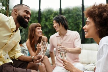 Sıradan arkadaşlar güler ve birlikte geçirdikleri zamanı kutlamak için açık bir kafede içkilerini paylaşırlar..