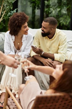 Genç arkadaşlar keyifli bir günde açık bir kafede dinlenirken kahkaha ve bağlantının keyfini çıkarırlar..