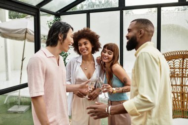 Bir grup arkadaş gülüyor ve açık bir kafede güneşli bir günün tadını çıkarıyor..