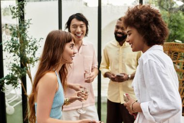Şık giyinmiş dört genç arkadaş canlı bir açık hava kafesinde birbirlerine eşlik ediyorlar..