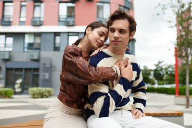 Sıcak bir parkta, genç bir çift kucaklaşırken birbirlerine eşlik etmekten zevk alır, sıcak bir gülümsemeyle..