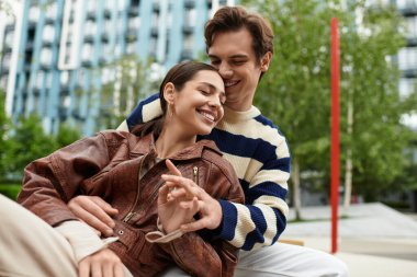 Neşeli bir çift, yeşilliğin ortasında, aşklarının sıcaklığında güneşlenen şefkatli bir kucaklaşmayı paylaşır..