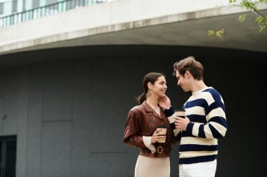 Bir çift modern mimari yapı altında sıcak içeceklerden hoşlanıyor..