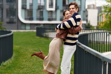 Genç bir çift birbirine sımsıkı sarılıyor, canlı bir parkta bir anlık sevgi ile eğleniyorlar..