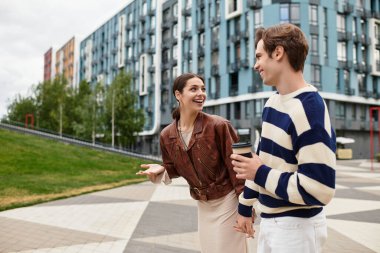 Çift el ele yürür, güler ve canlı bir şehirde kahve paylaşır..