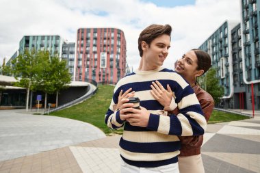 Genç bir çift aşklarını canlı bir şehir parkında paylaşıyor. Güneşin sıcaklığında güneşleniyorlar..