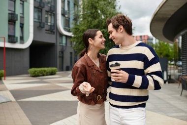 Mutlu genç çift, modaya uygun bir şehirde yürürken birbirlerine eşlik etmekten zevk alıyor..