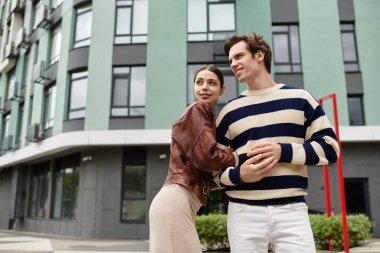 Sevgi dolu bir çift şık mimarisi olan bir şehir ortamında sıcak bir şekilde kucaklaşır..