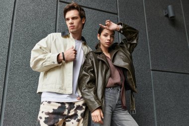 Sevgi dolu bir çift, şık giyinirken sıcak bir ilişkiyi kucaklayarak özgüvenle ayakta duruyor..