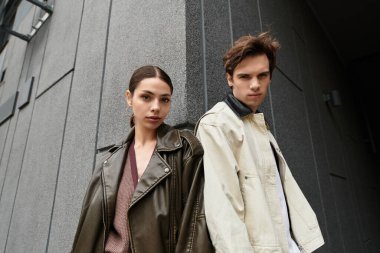 Sevgi dolu bir çift birbirine yakın durur, sıcaklığı yayar ve şık bir arkaplan karşısında iletişim kurarlar..