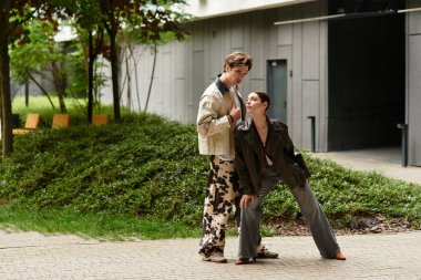 Bir çift güneşli bir günde şehir yeşilliği arasında sevgi dolu, neşeli bir etkileşimden zevk alır..