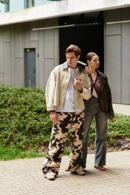 Sevgi dolu bir çift, yeşilliklerle dolu canlı bir şehir parkını keşfederken birbirlerini kucaklarlar..