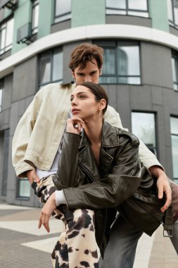 Genç çift, modaya uygun bir şehir ortamında poz verirken sevgilerini ifade ediyor.