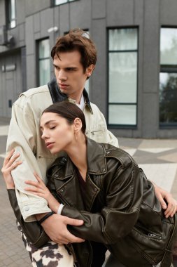 Bir çift genç aşık, şehir manzarasında kucaklaşır, sıcaklık ve şefkat saçar..
