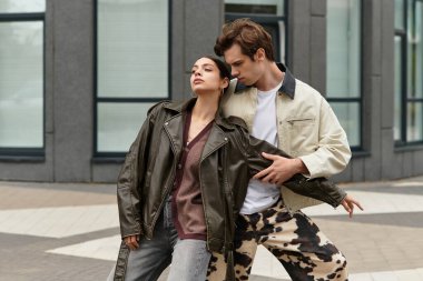 Sevecen genç çift, modaya uygun bir açık alanda poz verirken neşeli bir anın tadını çıkarıyor..