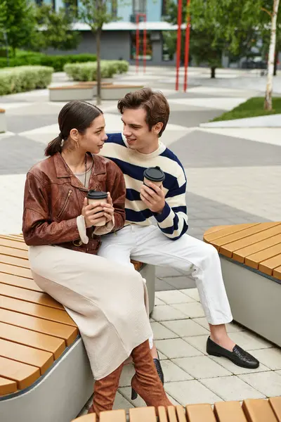 Bir çift gülüşlerini sıcak içeceklerle paylaşıyor. Canlı, romantik bir anda..