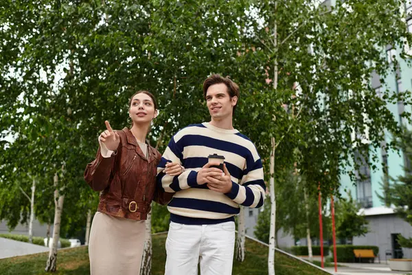 Genç bir çift, neşeli bir parkta yürürken birbirlerine eşlik etmekten zevk alır..