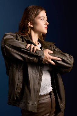 Güzel genç bayan sonbahar modasını mavi bir stüdyo ortamında sergiliyor.