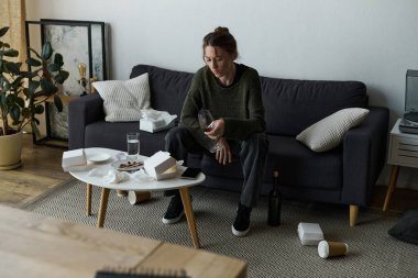 Sıcak bir oturma odasında, genç bir kadın sessizce oturur, duygularını ve çevresini düşünür..