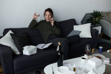 Genç bir kadın evdeki koltuğunda oturup telefonda konuşurken duygularını ifade ediyor..