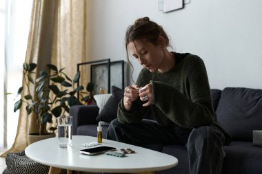 Genç bir kadın evinde sessizce oturur, düşünceleriyle çevrili iken duygularını yansıtır..