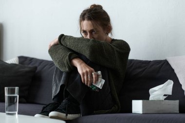 Genç bir kadın, derin düşüncelere dalmış, üzüntüsüyle boğuşuyor..