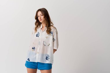 Şık, genç bir kadın, canlı yaz kıyafetleri içinde, moda yeteneğini sergiliyor..