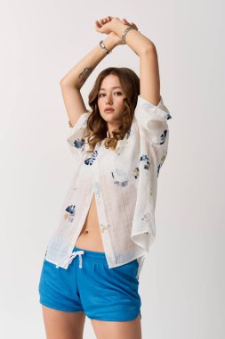 Tarz sahibi genç bir kadın, minimalist bir ortamda aktif bir pozisyona güvenir..