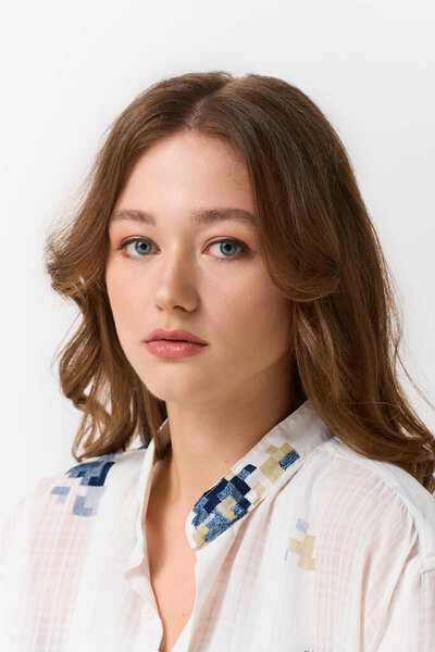 Красивая молодая женщина уверенно позирует в стильной одежде, демонстрируя свое яркое чувство моды.