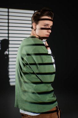 Modaya uygun bir genç, gençlik kültürünü eşsiz ışıklandırmasıyla karamsar bir ortamda sergiliyor..