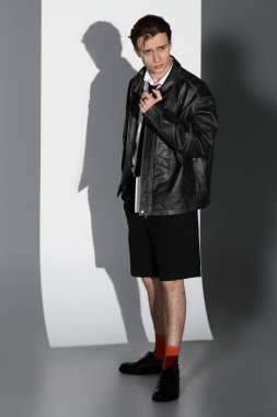 Genç adam şık bir kıyafet içinde modern gençlik kültürünün özünü yakalıyor..