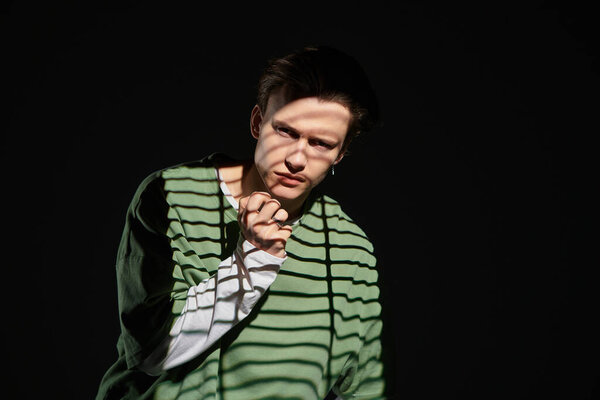 A stylish teenager with striking features showcases youthful culture while lost in contemplation.