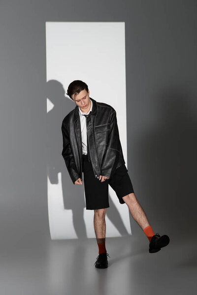 Confident teen poses in a stylish outfit against a minimalist backdrop.