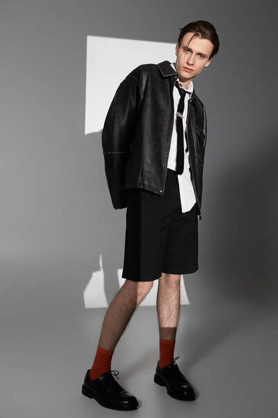 Confident teenager poses in stylish attire, reflecting contemporary fashion and youth culture.