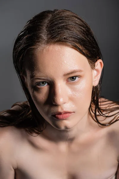 High angle view of model with wet face looking at camera isolated on grey — Stock Photo