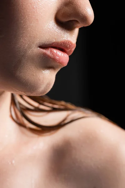 Close up view of woman with wet skin and lips isolated on black — Stock Photo