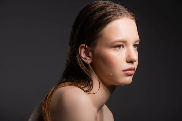 Schönhaariges Model mit feuchtem Gesicht, das isoliert von Grau wegschaut — Stockfoto
