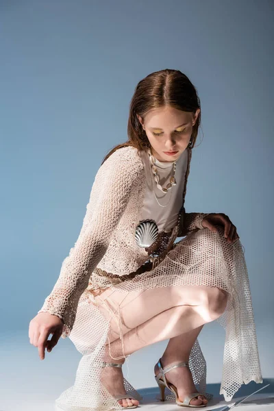 Jovem sereia em malha de lã e saia de meia-calça em gradiente fundo azul com luz — Fotografia de Stock