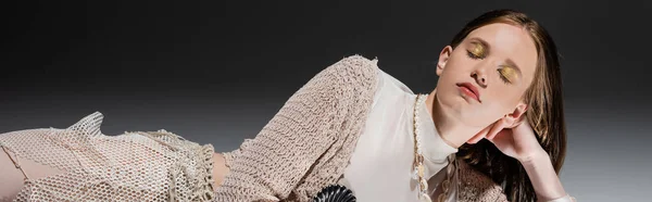 Русалка с золотым макияжем и юбка из рыболовных сетей, лежащая на сером фоне, баннер — стоковое фото