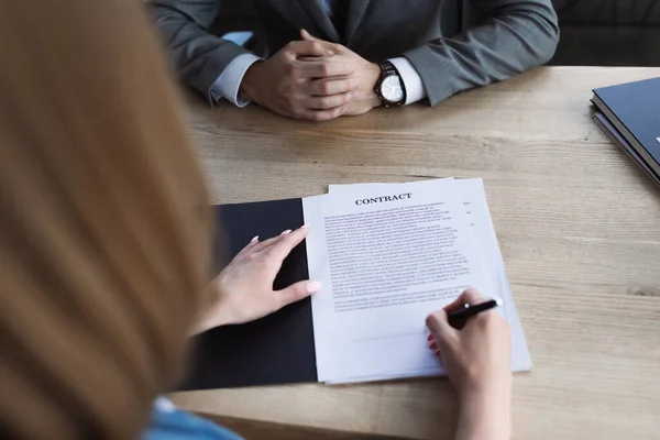 Vista cortada do contrato de assinatura do candidato perto do empresário durante a entrevista de emprego — Fotografia de Stock